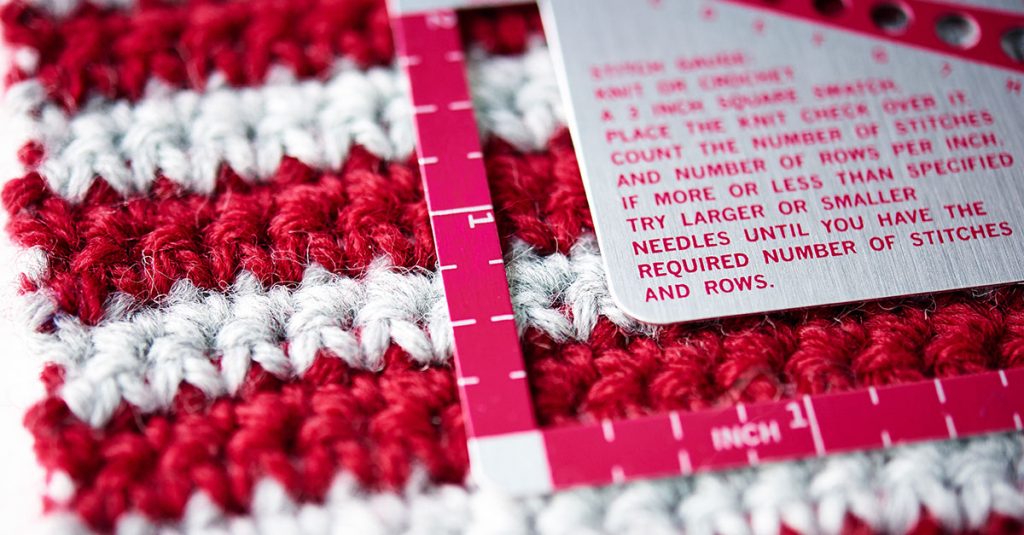 Red and white crochet square with ruler on top