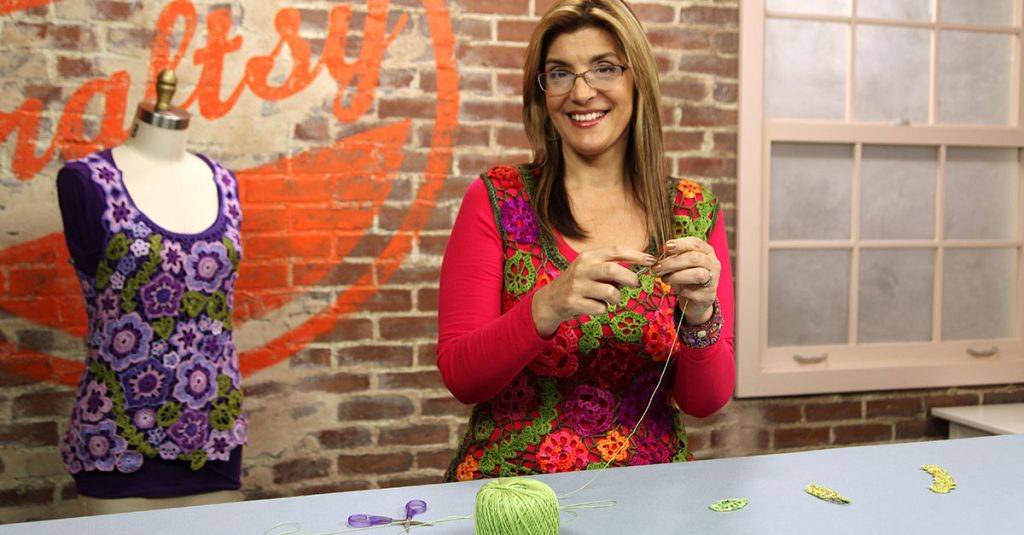 Woman standing and knitting with green yarn