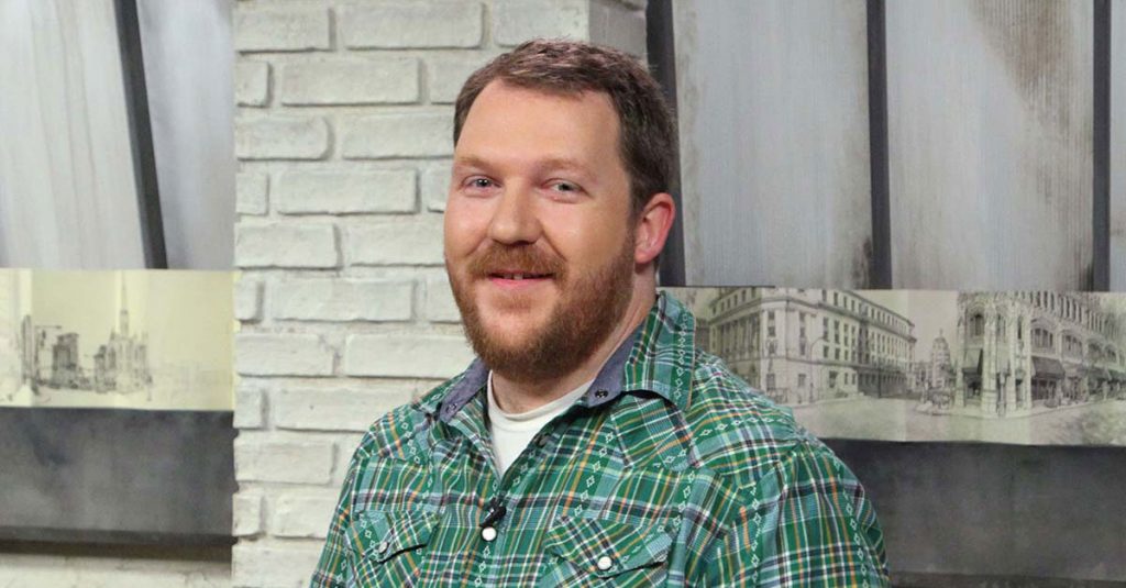 Man smiling in front of sketches