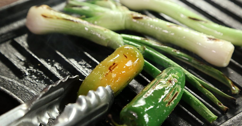 Peppers and chives being grilled