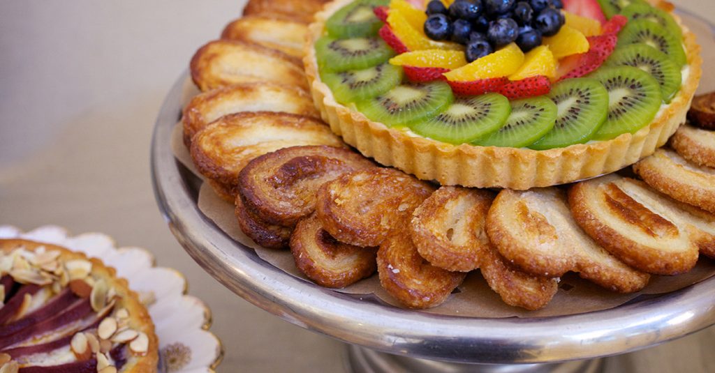 Fruit tart surrounded by pastries