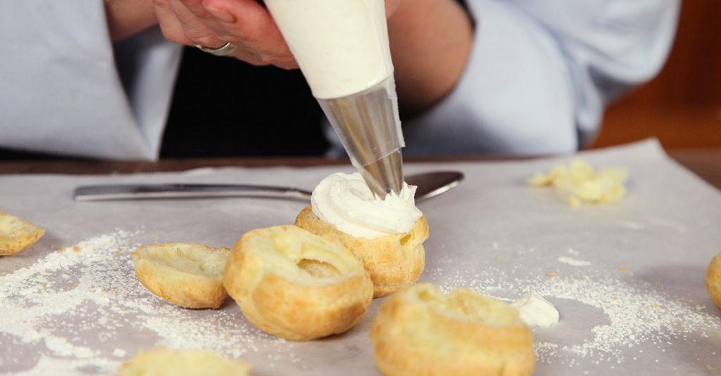 Adding cream to a pastry