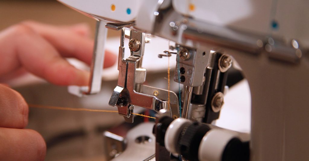Close up of orange thread through a machine