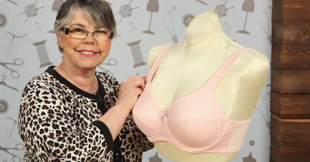 Woman posing near a bra on a form