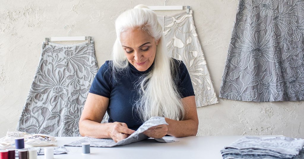 Woman with long white hair sewing