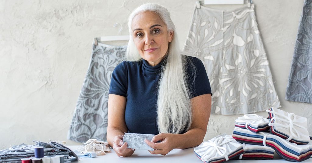 Woman with white hair holding fabric squares