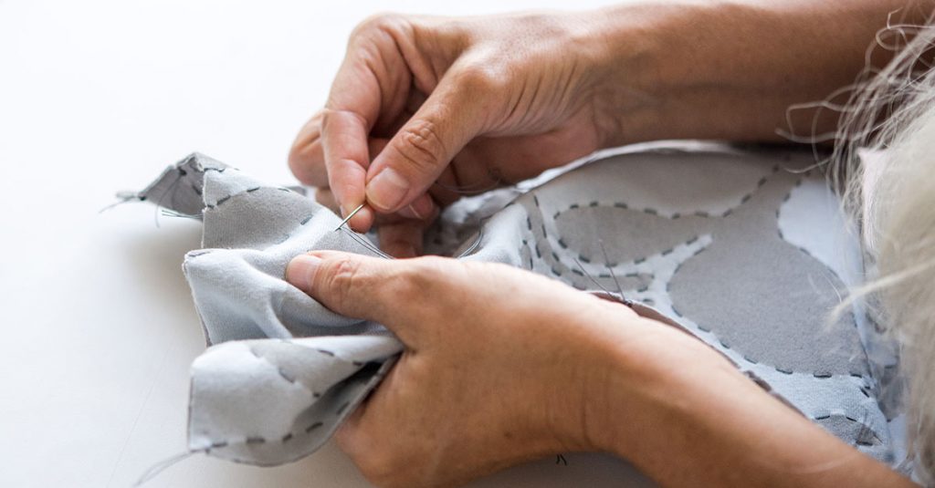 Hand sewing around a pattern