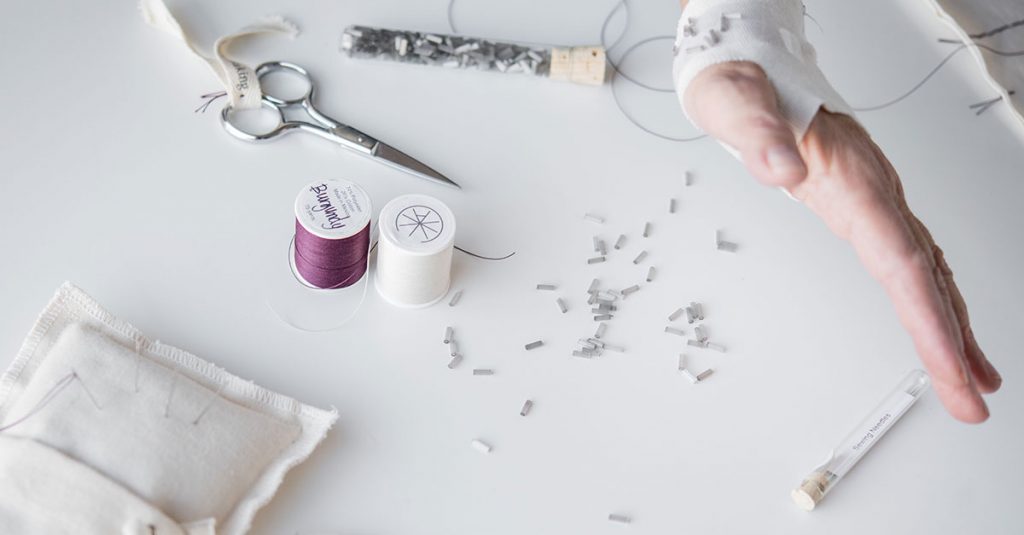 Hand near thread spools