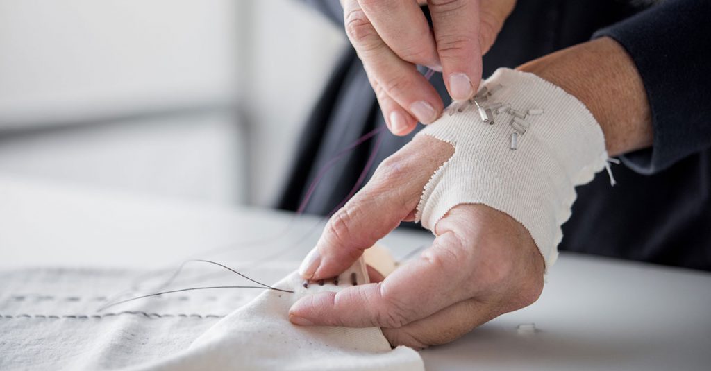 Person adding beading to their sewing