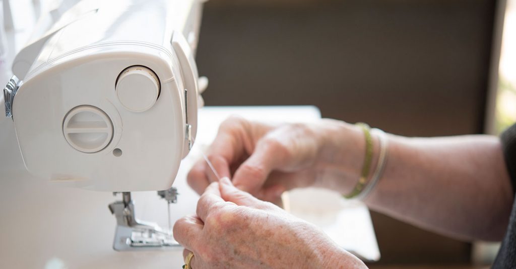 Person holding thread new sewing machine