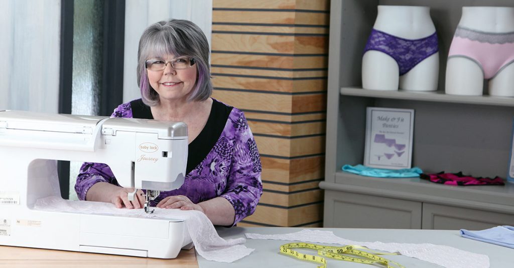 Woman in a purple shirt using a sewing machine