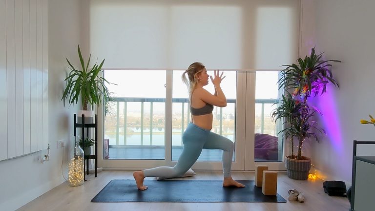 Woman doing a yoga pose in front of large windows