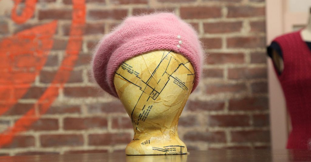 Knit pink hat on a form