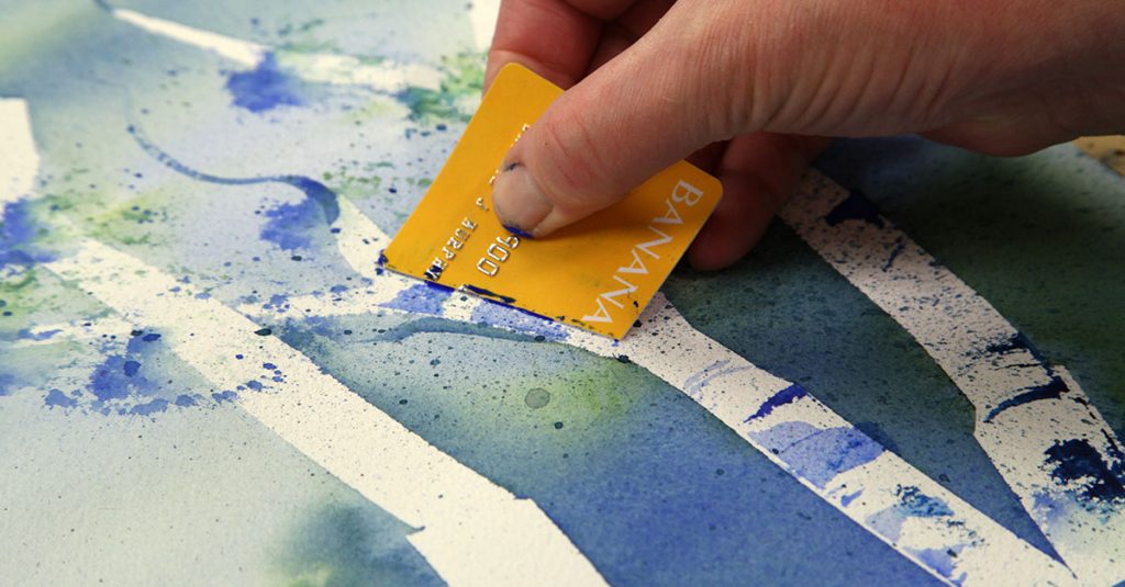Person using a bank card for watercolor paint
