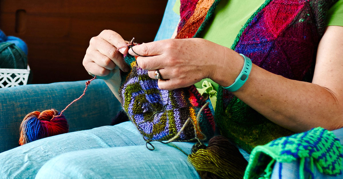 Person knitting with colorful yarn