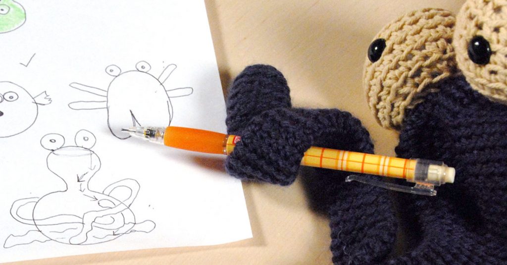 Knit animal holding a pencil
