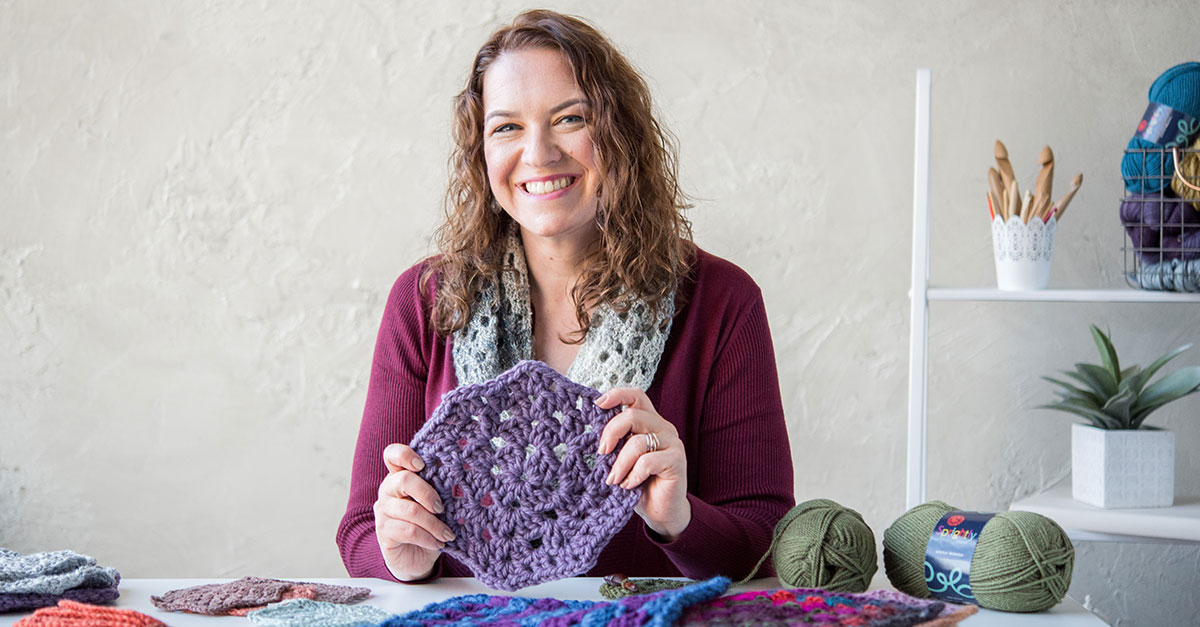 Woman holding purple crochet piece