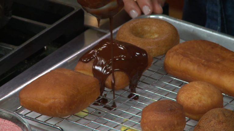 pouring chocolate glaze over donuts