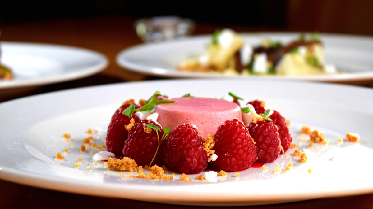 A plated dessert featuring raspberries.