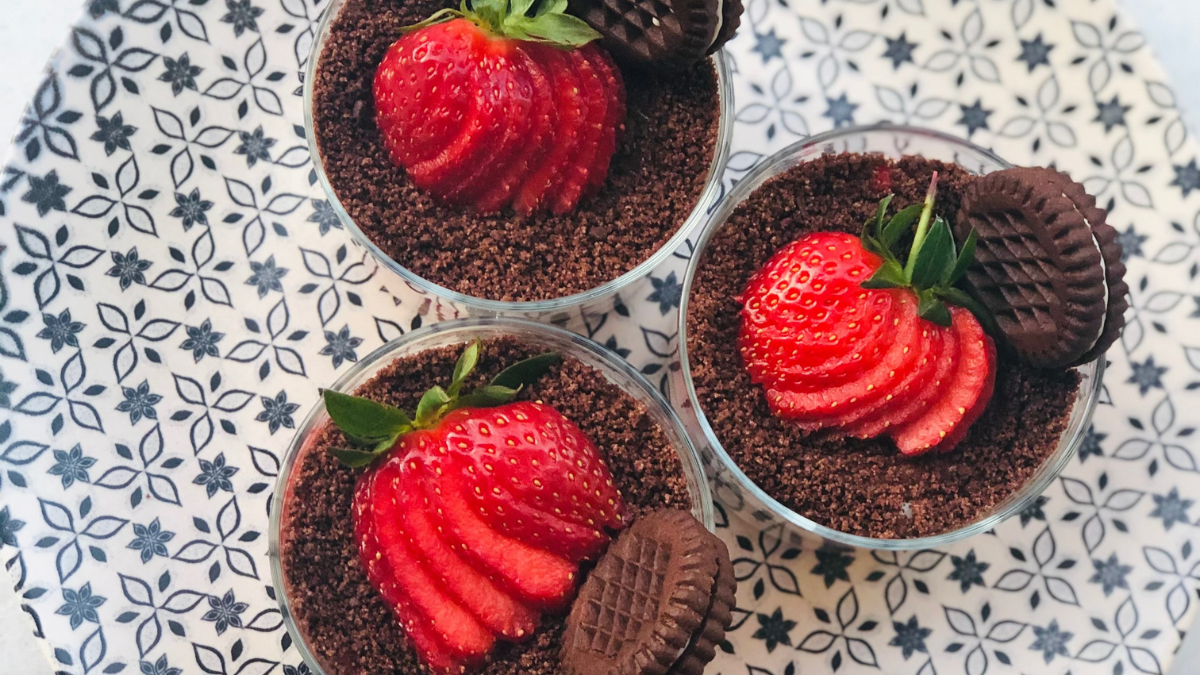 three desserts with strawberries and chocolate on a plate.
