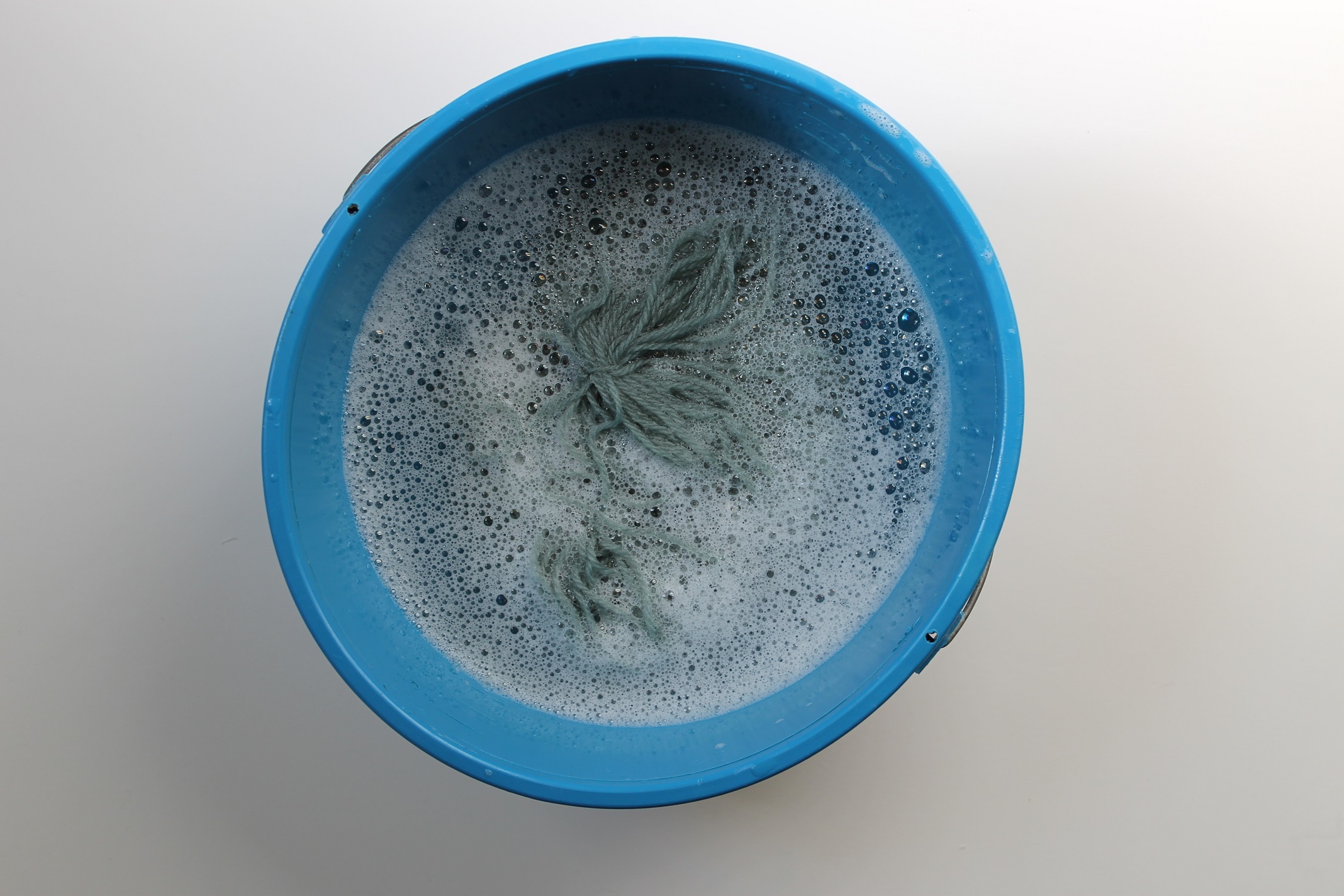 Washing coned yarn: Submerging it in Basin
