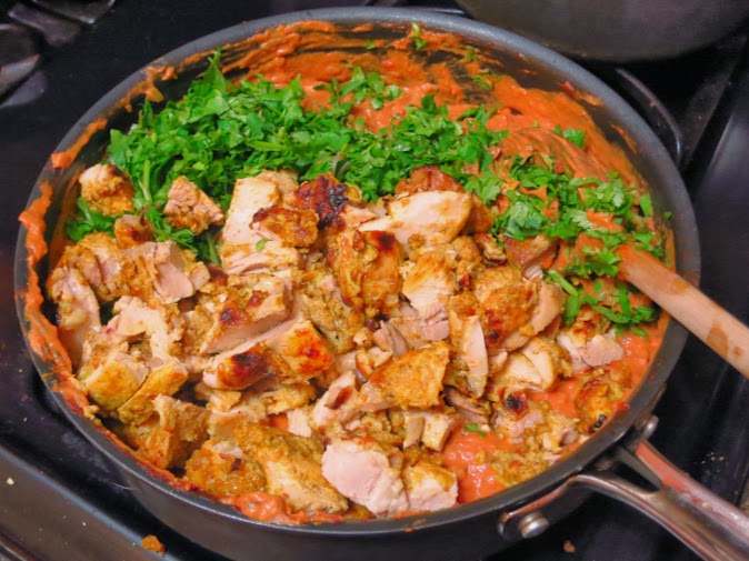 Stirring the chicken and cilantro into the tikka masala sauce