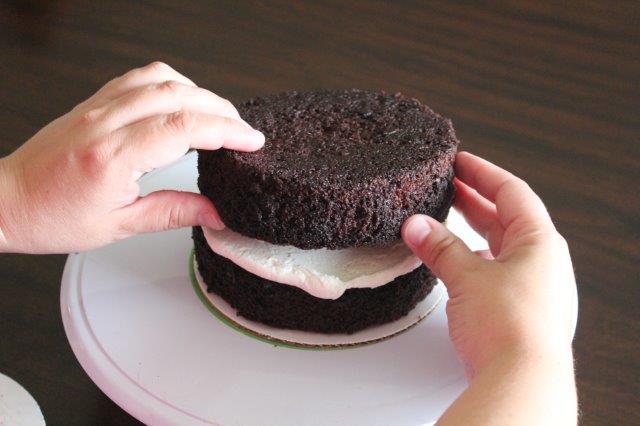 Second Tier of a Chocolate Cake Getting Stacked 