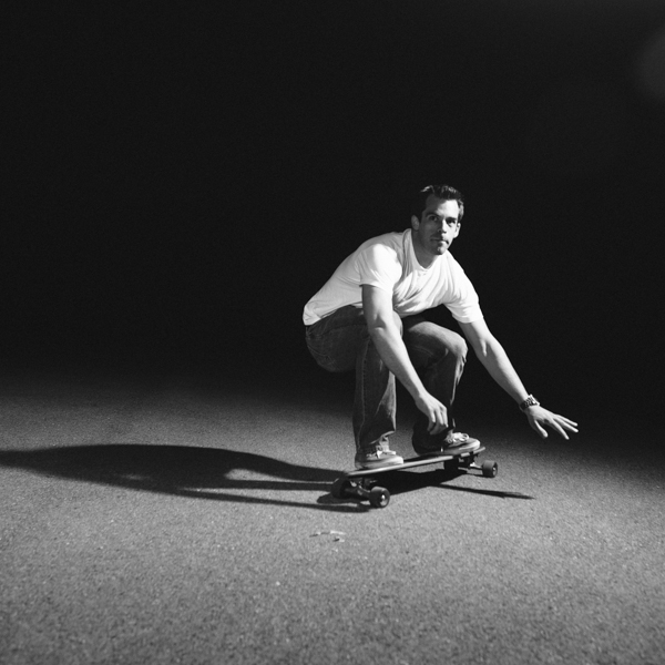 Black and White Photo of a Man Skateboarding