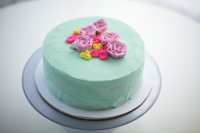 surround pink buttercream roses with mini hot pink and yellow rosettes