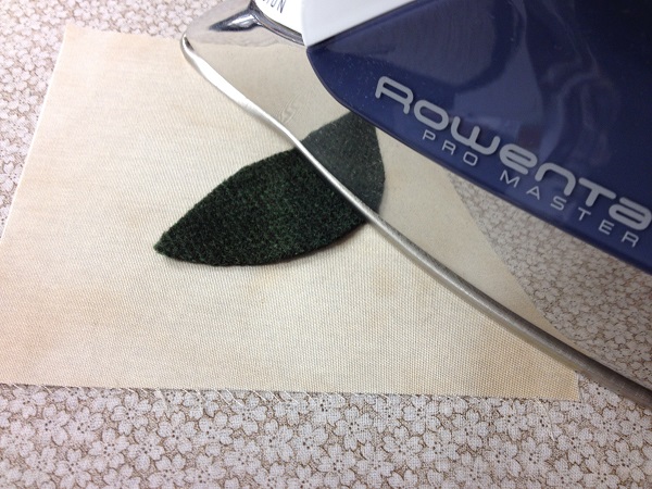 pressing wool shape to background fabric with iron