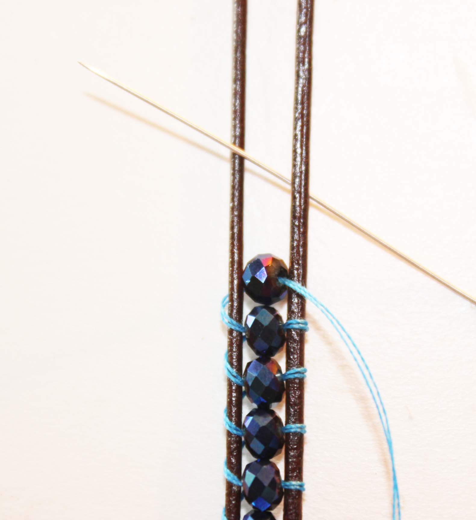 Add the bead pull thread over top of cord loop around the cord and up through center