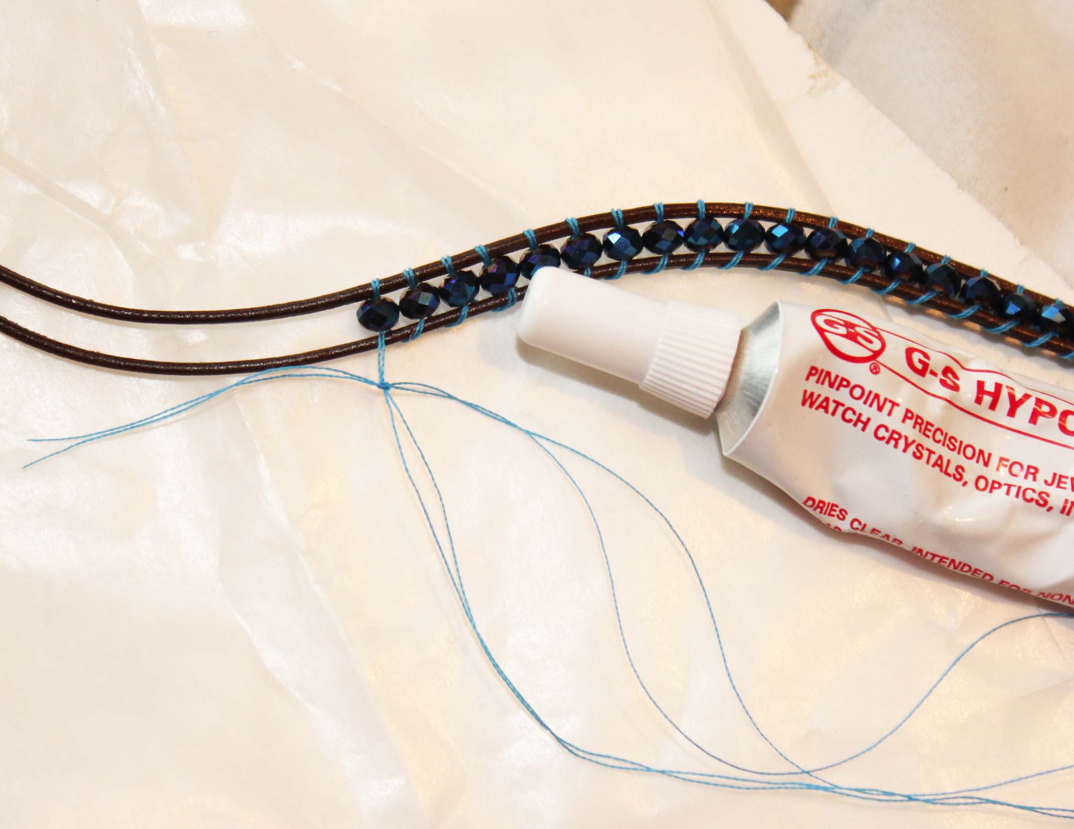 Add new thread to continue adding beads by knotting new thread to old and glueing with hypo cement