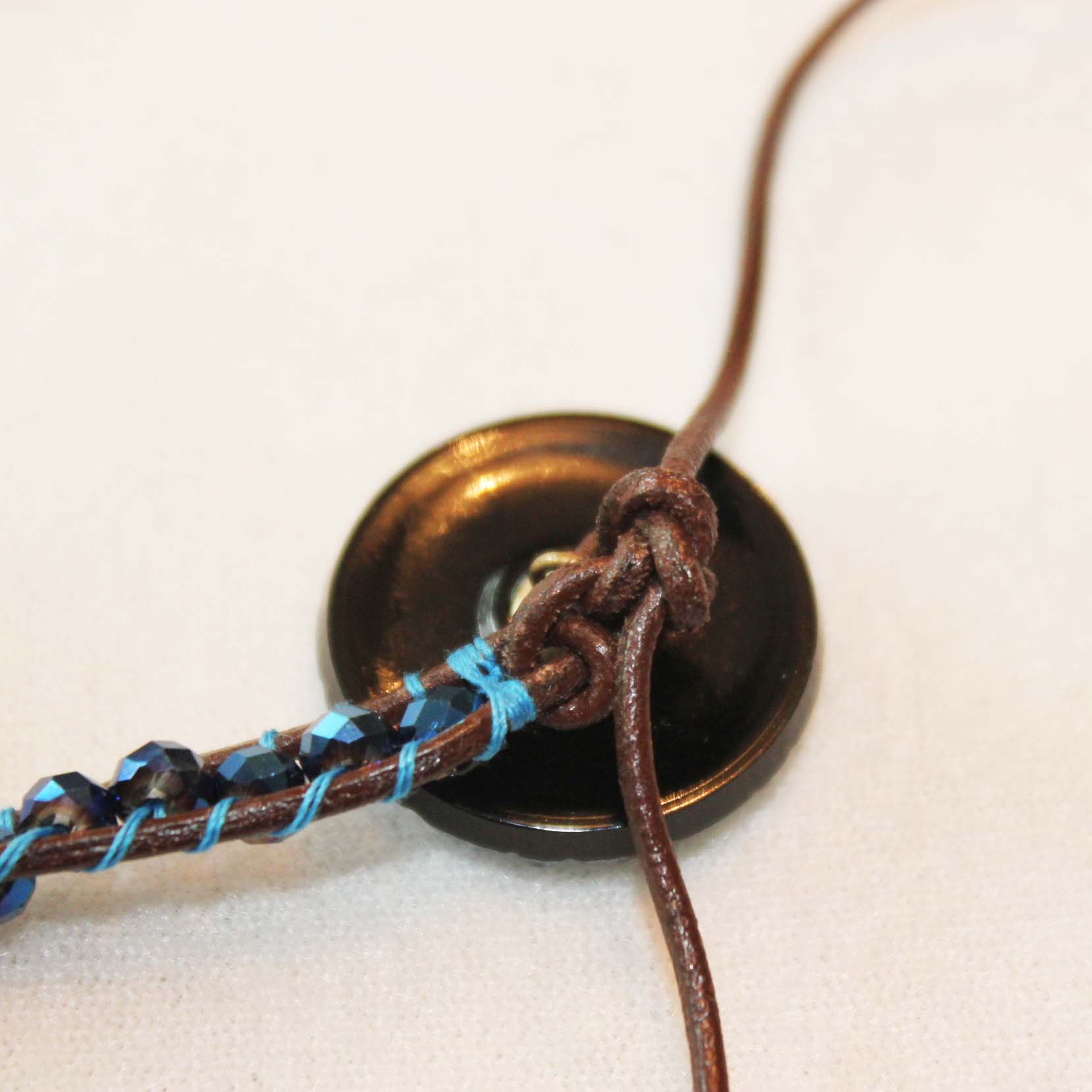 Tie a knot in the leather to finish, trim ends and glue all leather and thread knots