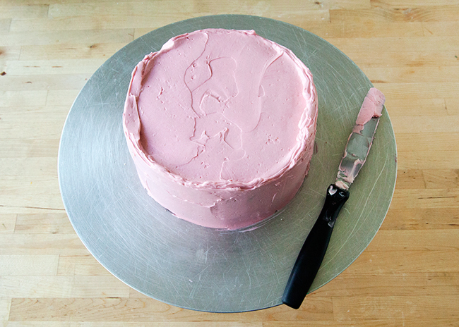 Crumb Coating: Cake frosted in pink buttercream