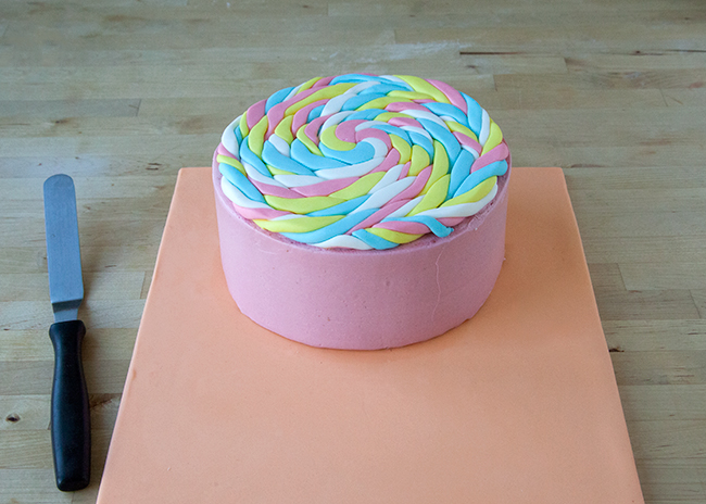 Place fondant lollipop disk on top of layer cake