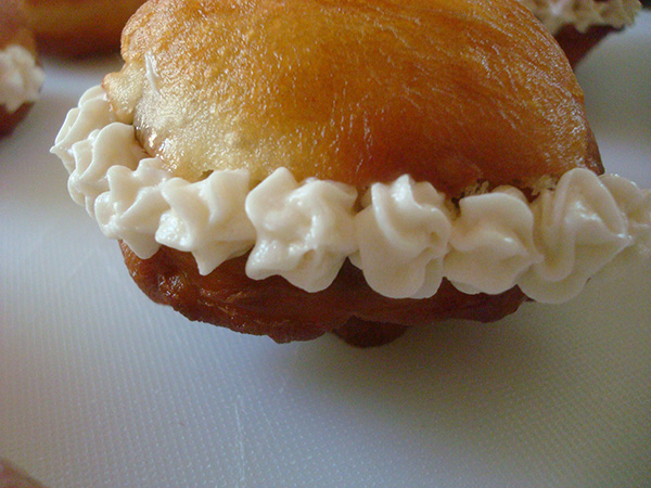 Jelly filled doughnut with piped cream around the outside
