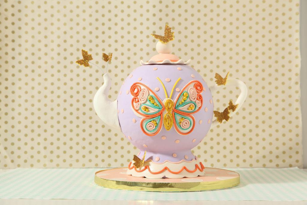 Whimsical teapot cake with floating butterflies