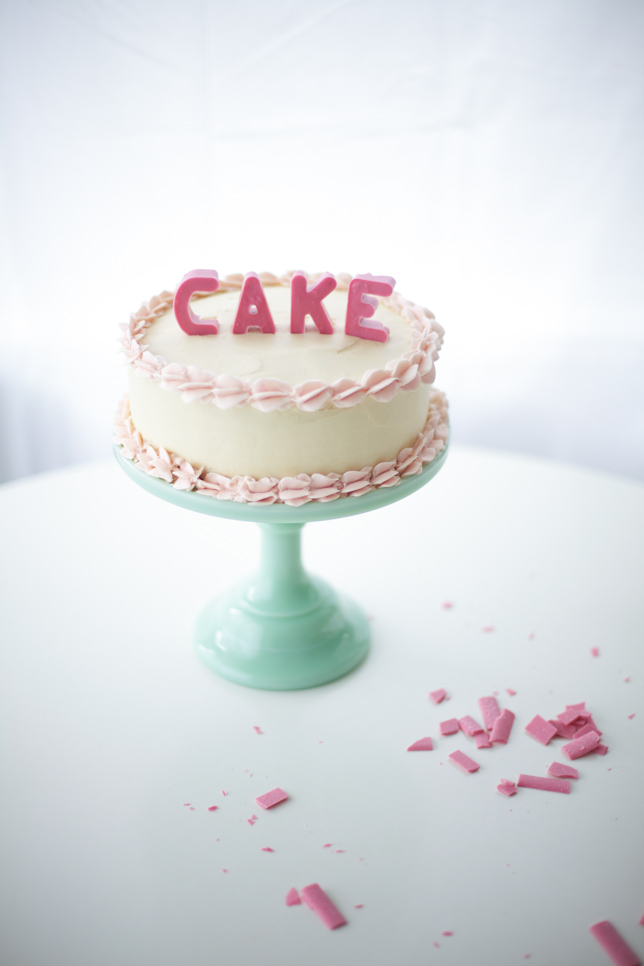 buttercream cake with pink lettering spelling CAKE
