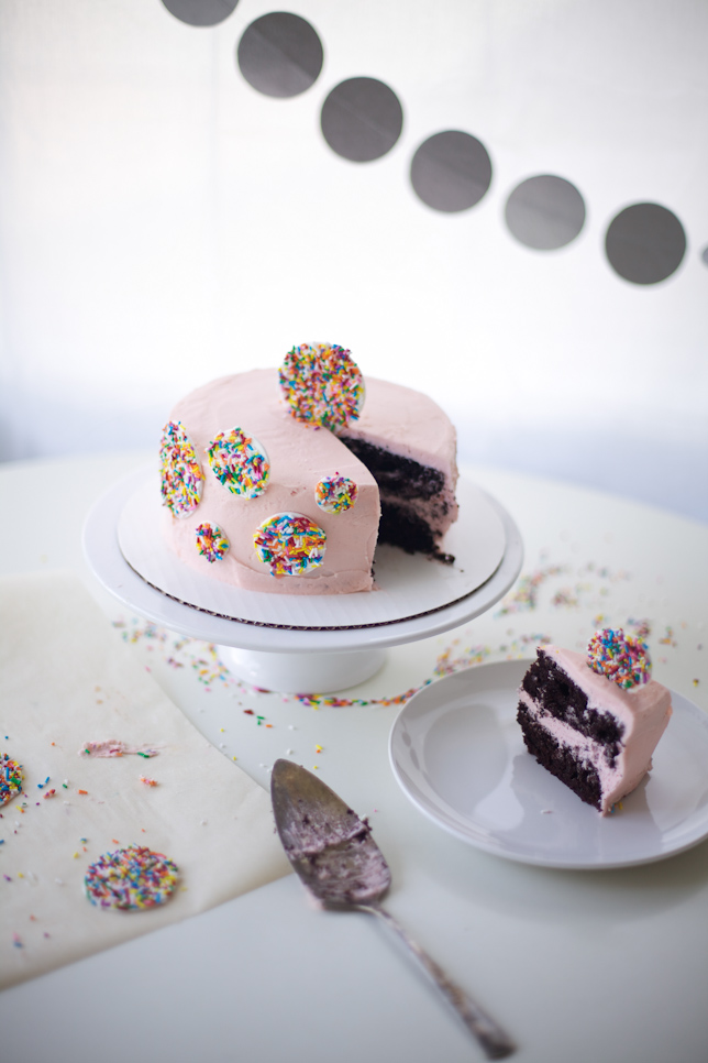 Slicing a delightful layer cake decorated with rainbow sprinkles!