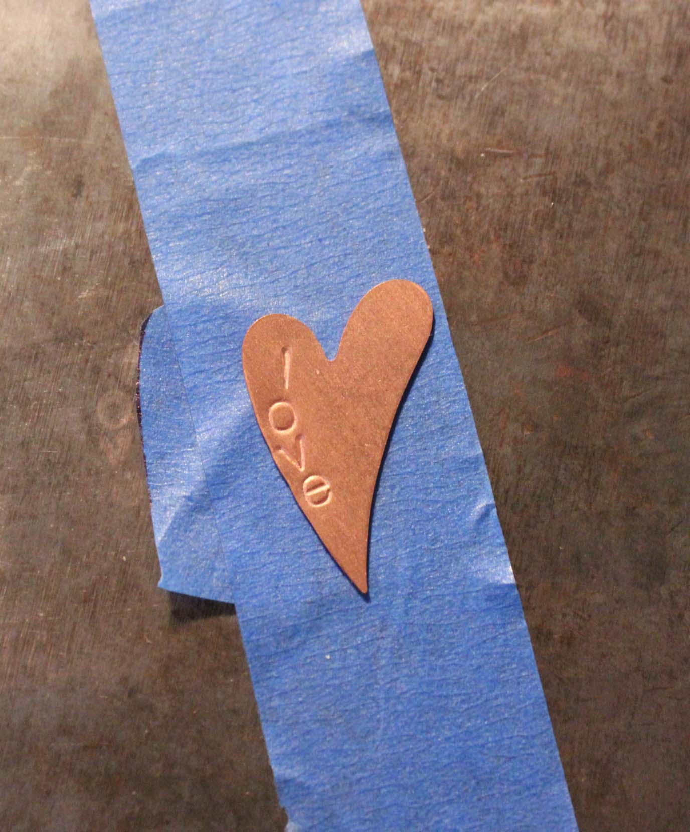 Heart shaped blank has been stamped with the letters l-o-v-e