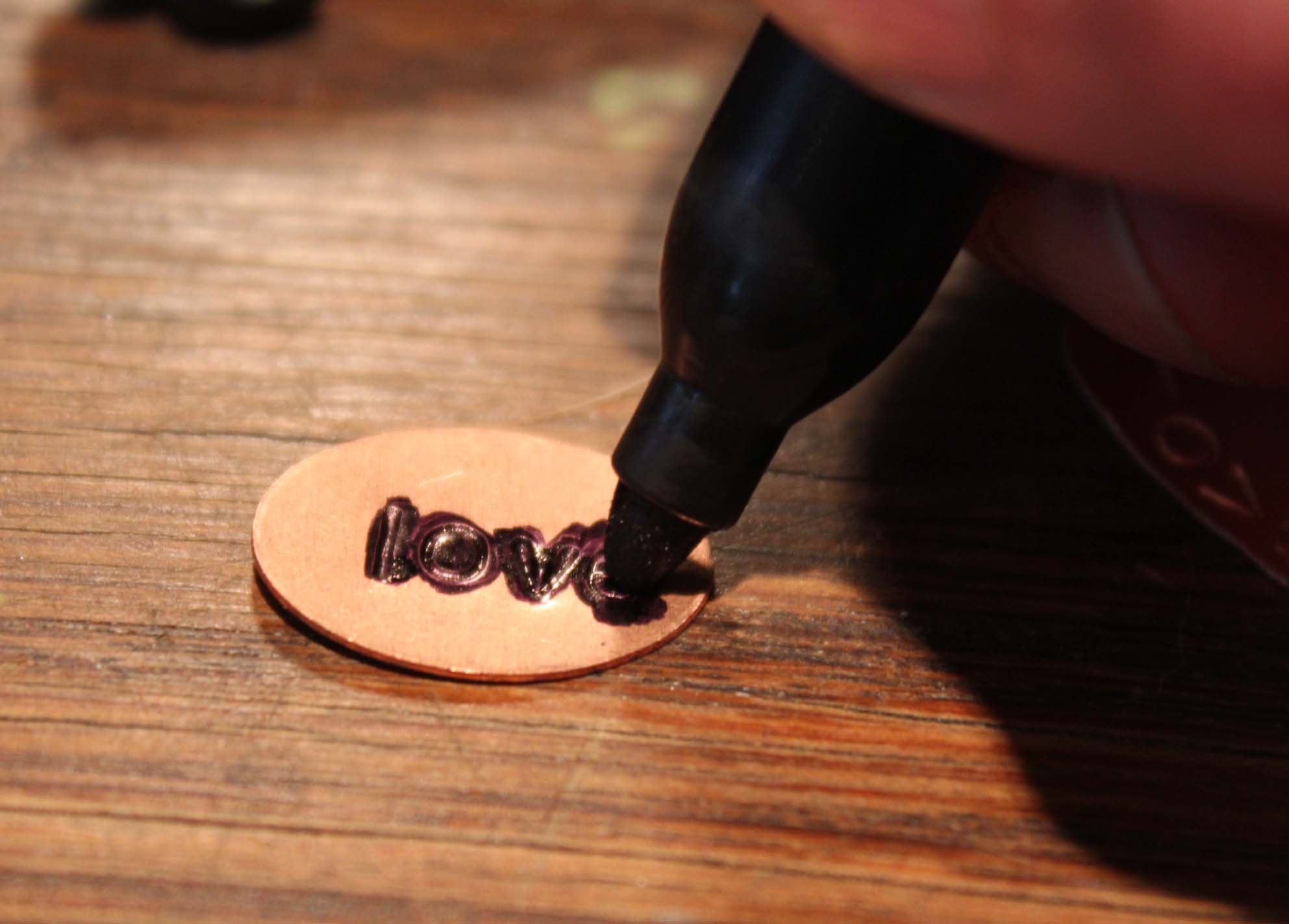 A permanent marker being used to darken the impressed letters