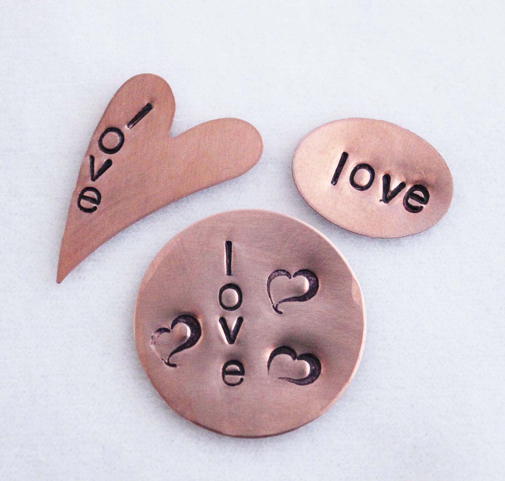 Three different shaped blanks hand stamped with the word love