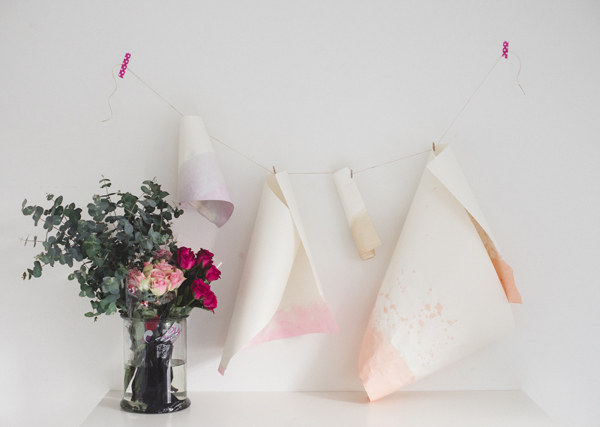 Dyed Paper Hanging Next to a Bouquet of Flowers