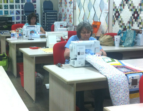 Students learning how to machine quilt on regular sewing machines
