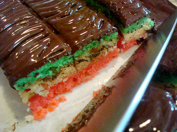 Trimming the edges off of the rainbow cookies