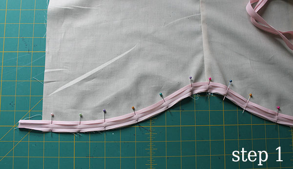 unfold one edge of your bias tape and pin it to the bottom hem
