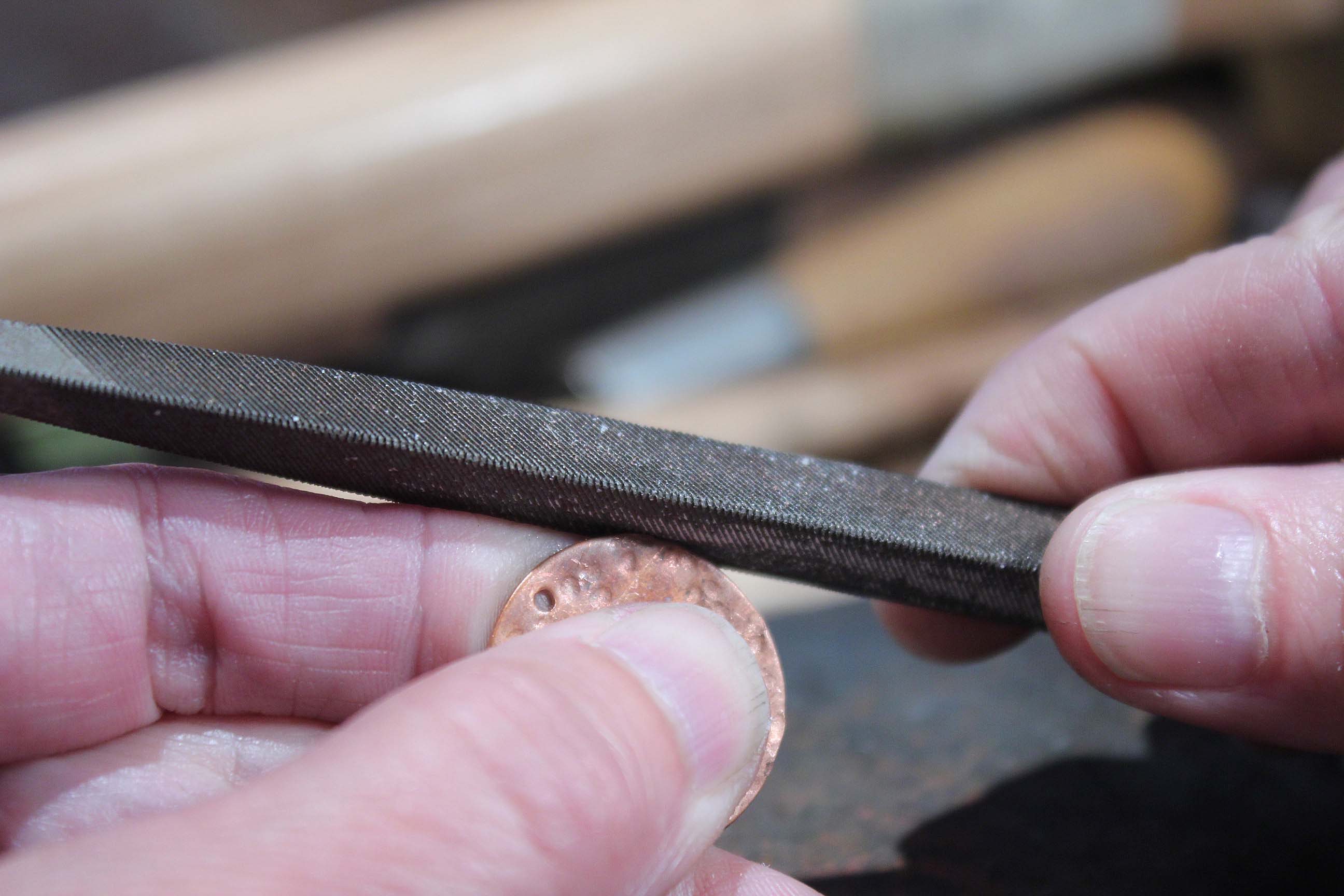 Using a file on the edges of a copper disc