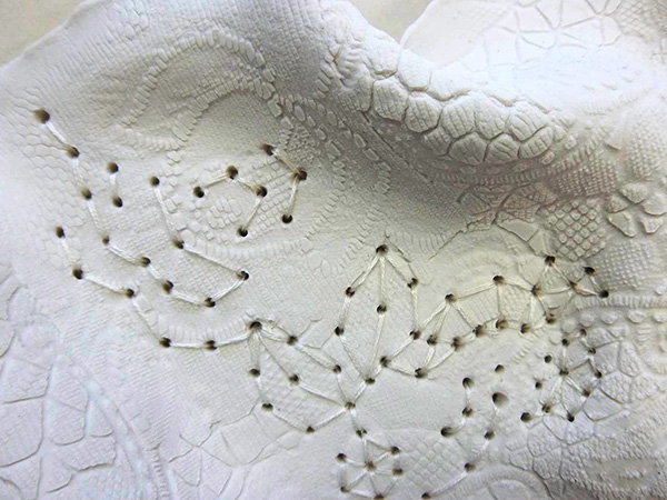 white embroidery into porcelain ceramic