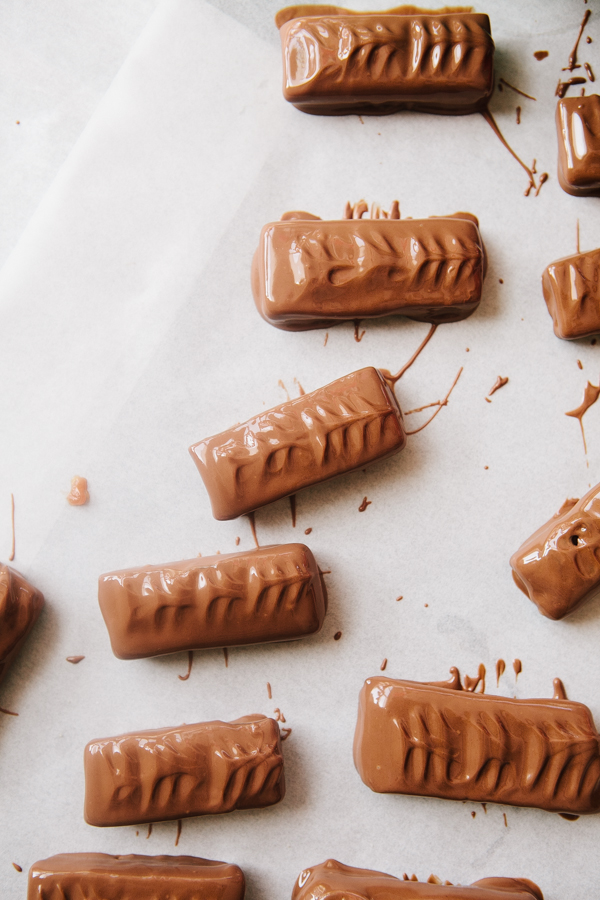 Dipping homemade twix bars in melted milk chocolate