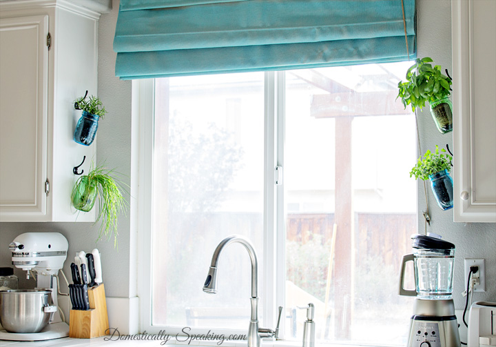 Kitchen Window Adorned With Hanging Herb Jars